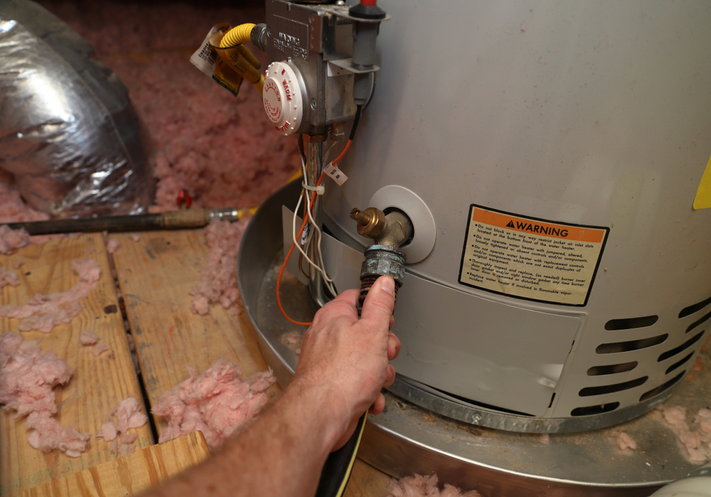 Hand attaching hose to a home water heater