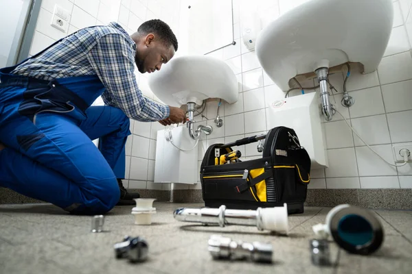 Plumber fixing bathroom sink